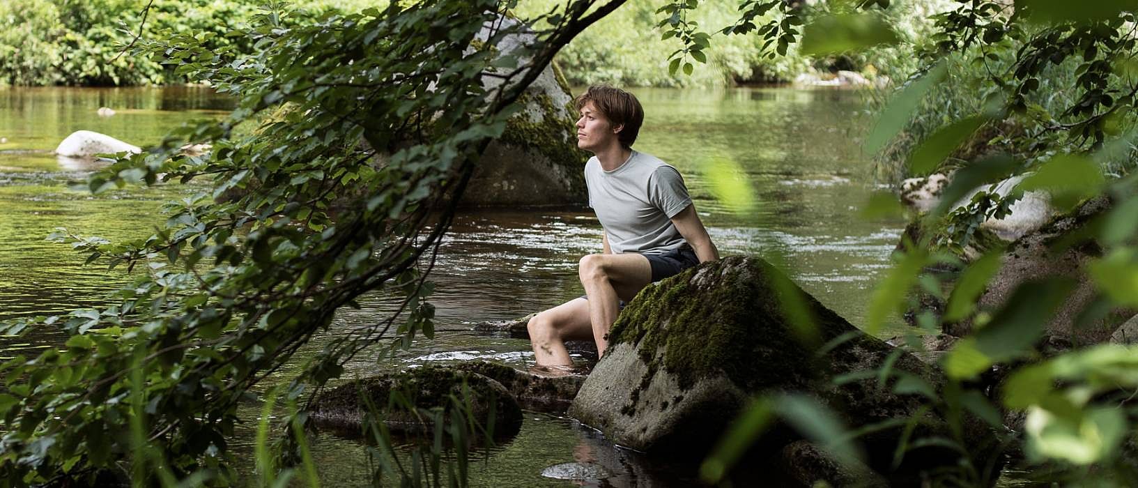 man sitting at river